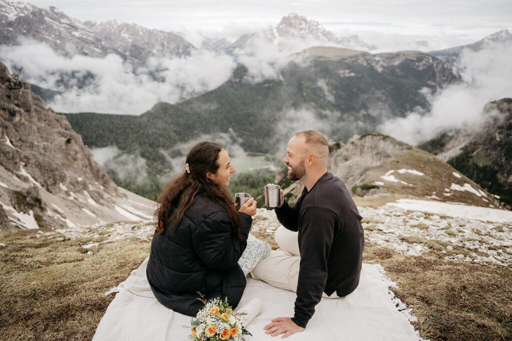 Couple drinking coffee on mountain picnic