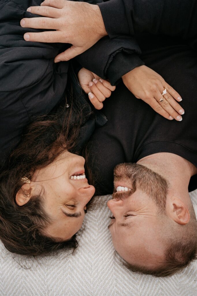 Couple smiling while lying face to face.