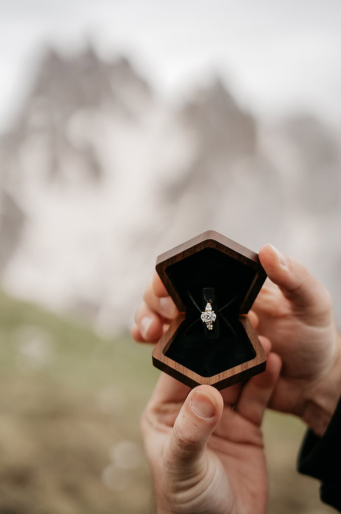 Diamond ring in wooden box, held outdoors