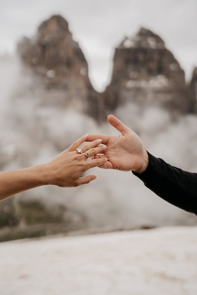 Two hands reaching in misty mountains