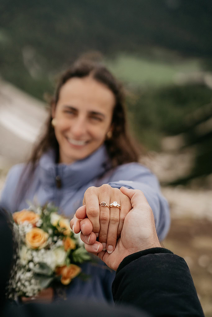 Couple holding hands, showing engagement ring.