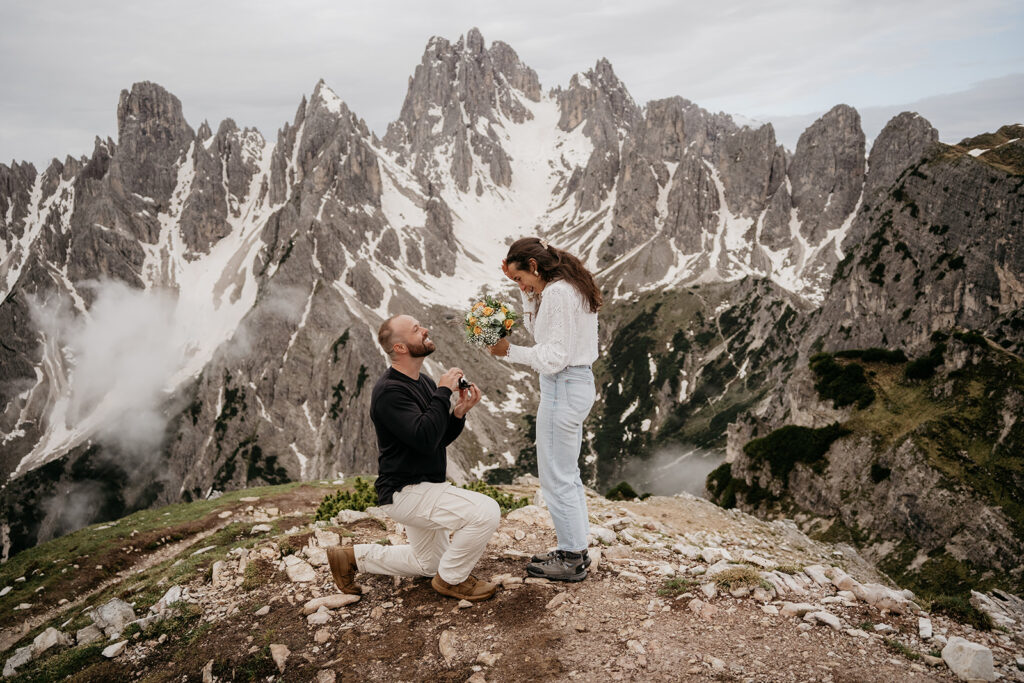 Mountain proposal with snowy peaks and happy couple