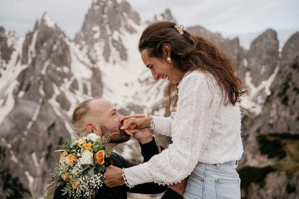 Proposal in snowy mountain backdrop with bouquet