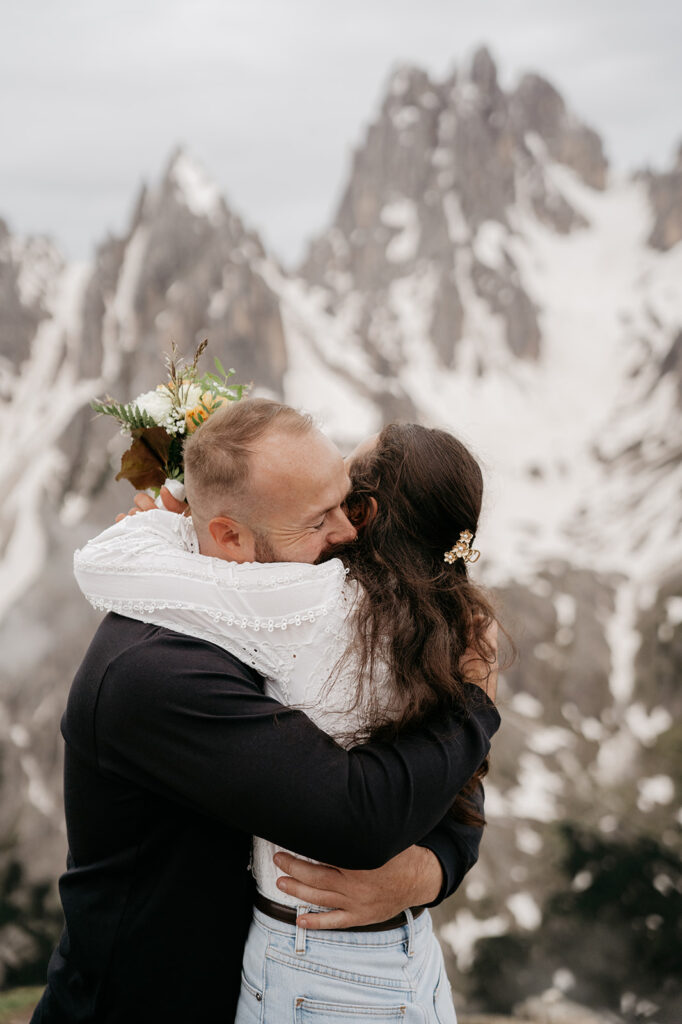 Couple embraces in snowy mountain landscape