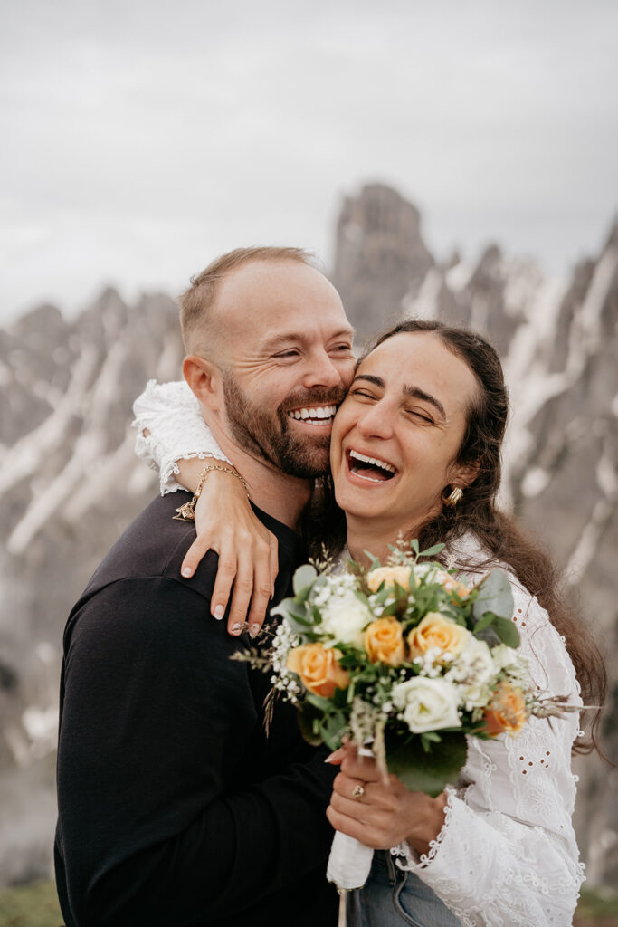 Happy couple with bouquet in mountain setting