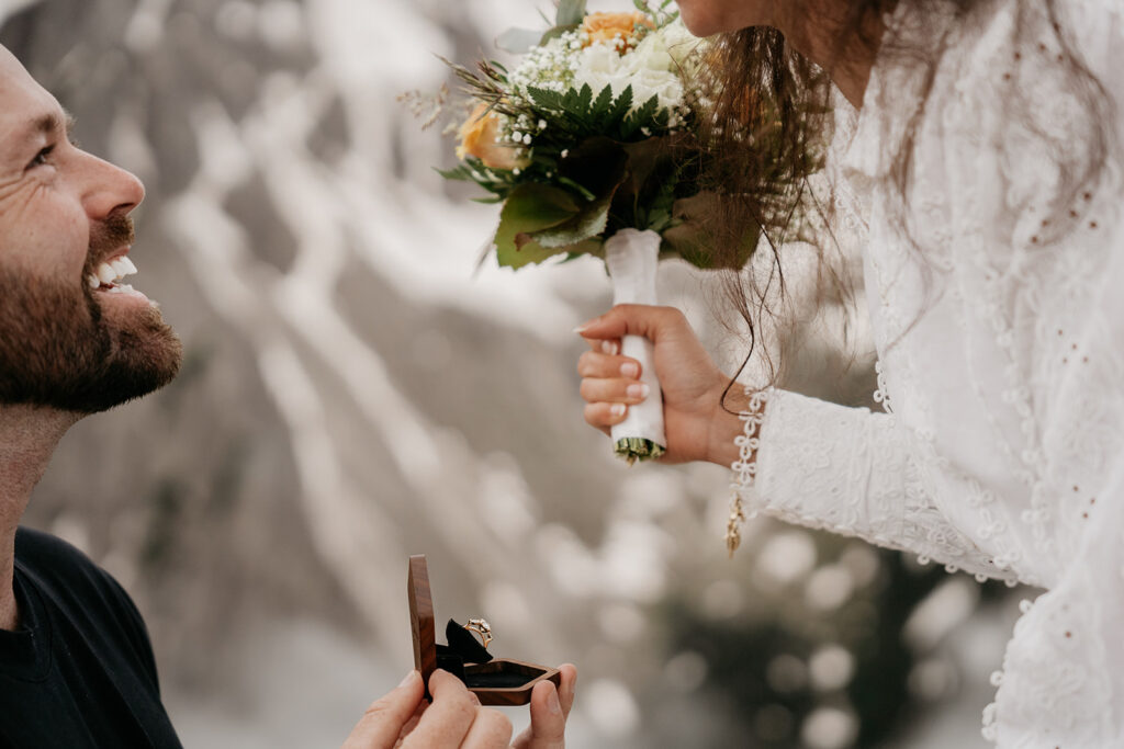 Man proposing with ring, woman holds bouquet.