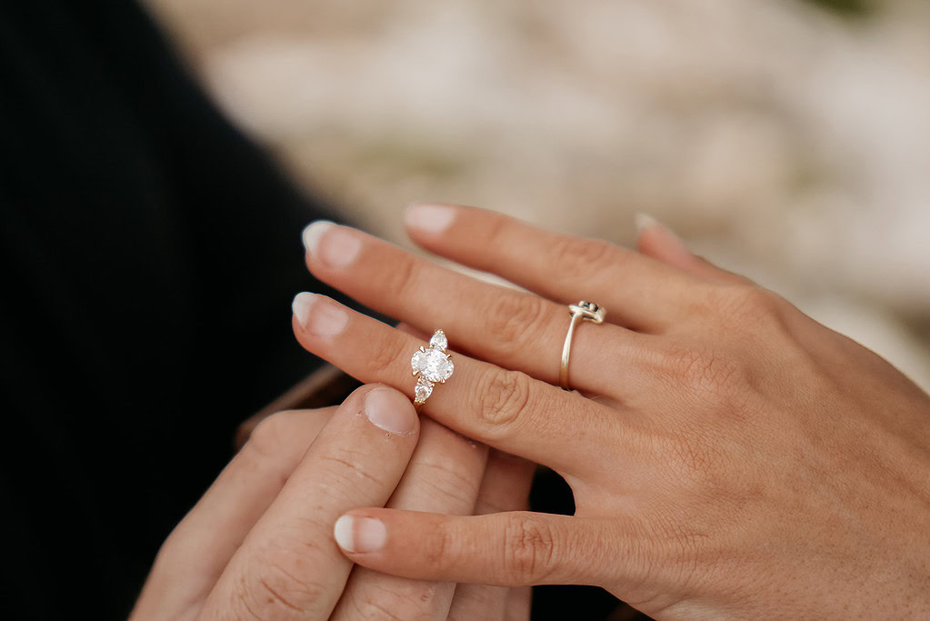 Close-up of a diamond engagement ring on finger.