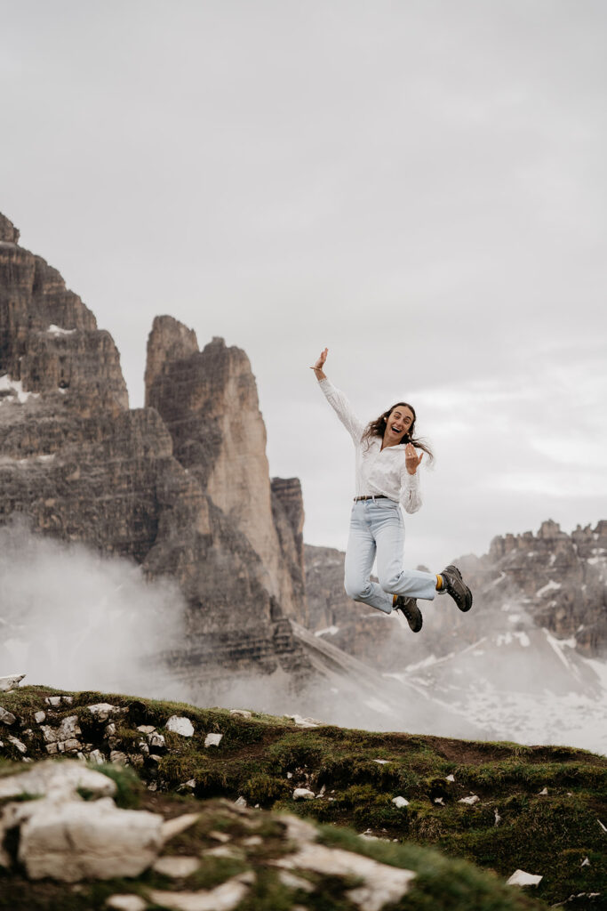 Person joyfully jumping in mountain landscape