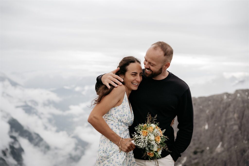 Smiling couple embraces with mountain view.