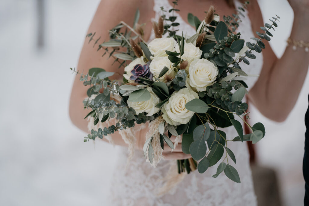 Bride holding white rose bouquet