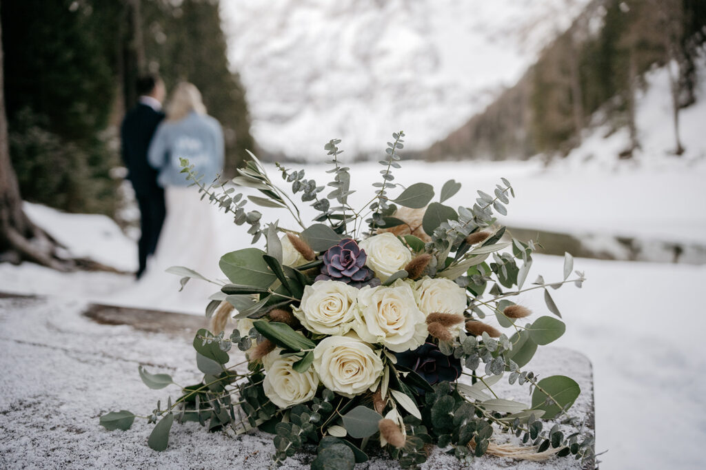 Bridal bouquet with couple in snowy background