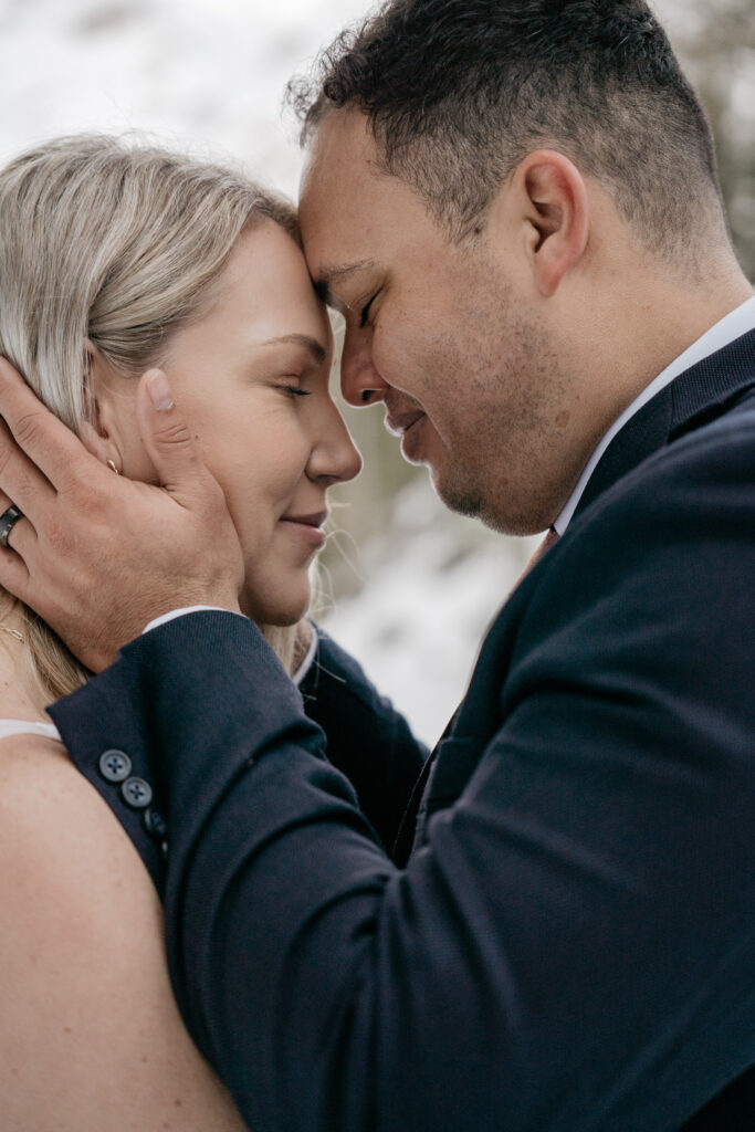 Couple embracing with closed eyes outdoors.