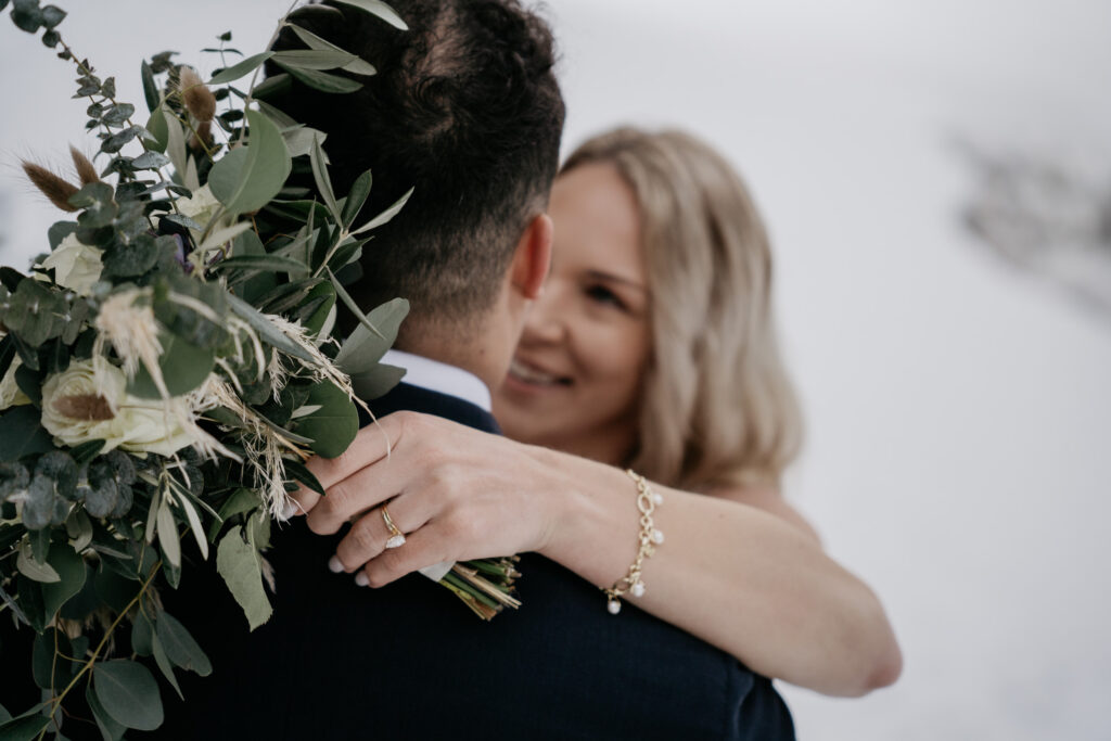 Bride embraces groom with bouquet