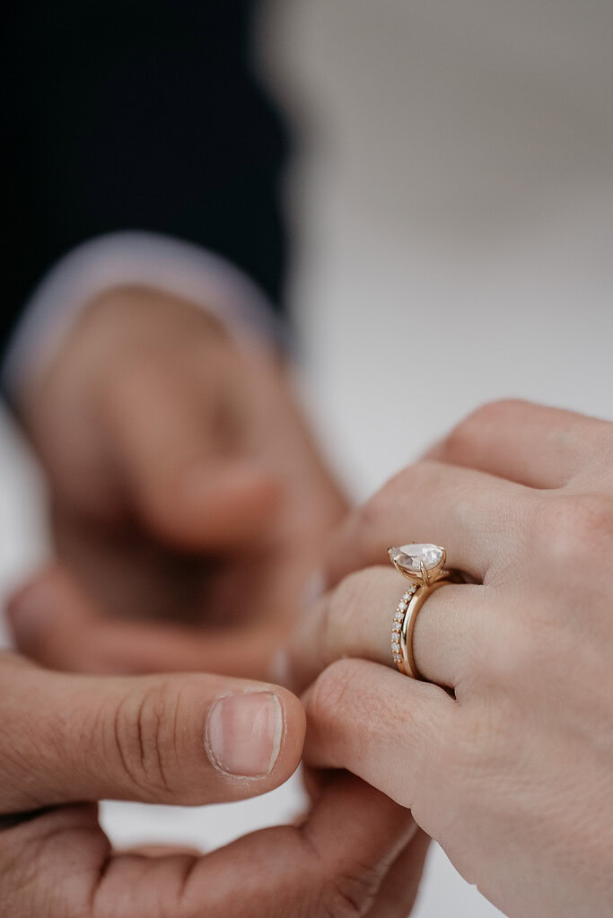 Hands holding with diamond engagement ring visible