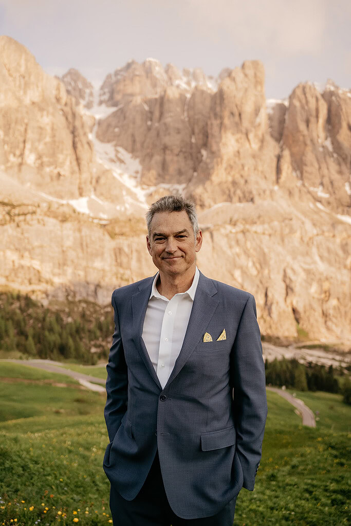 Man in suit standing in mountain landscape