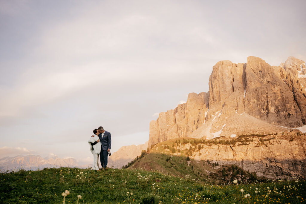 Couple embracing by mountain at sunset