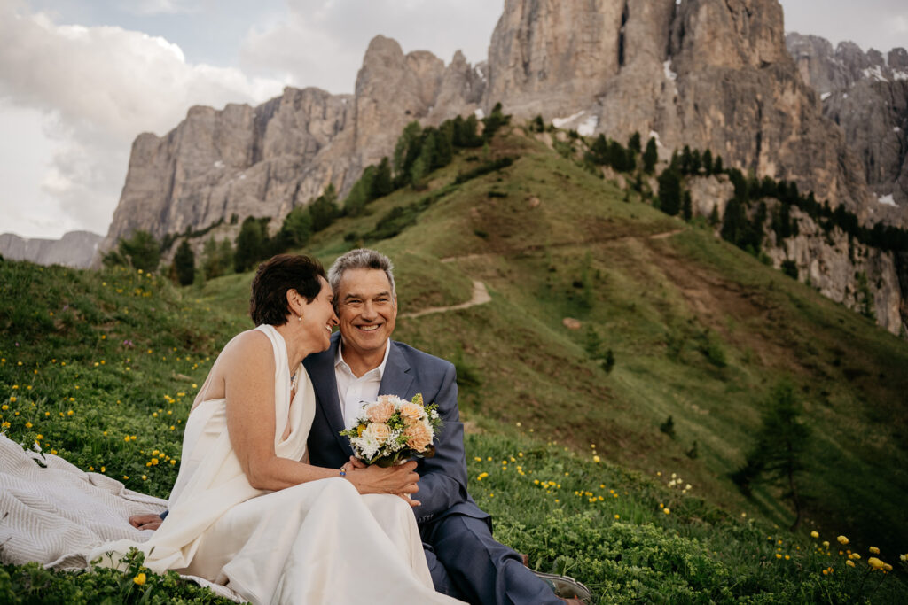 Couple smiling in a mountainous landscape.