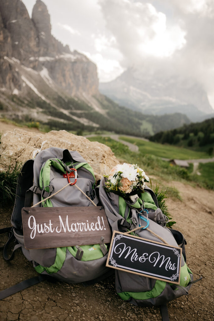 Backpacks with wedding signs on mountain trail.