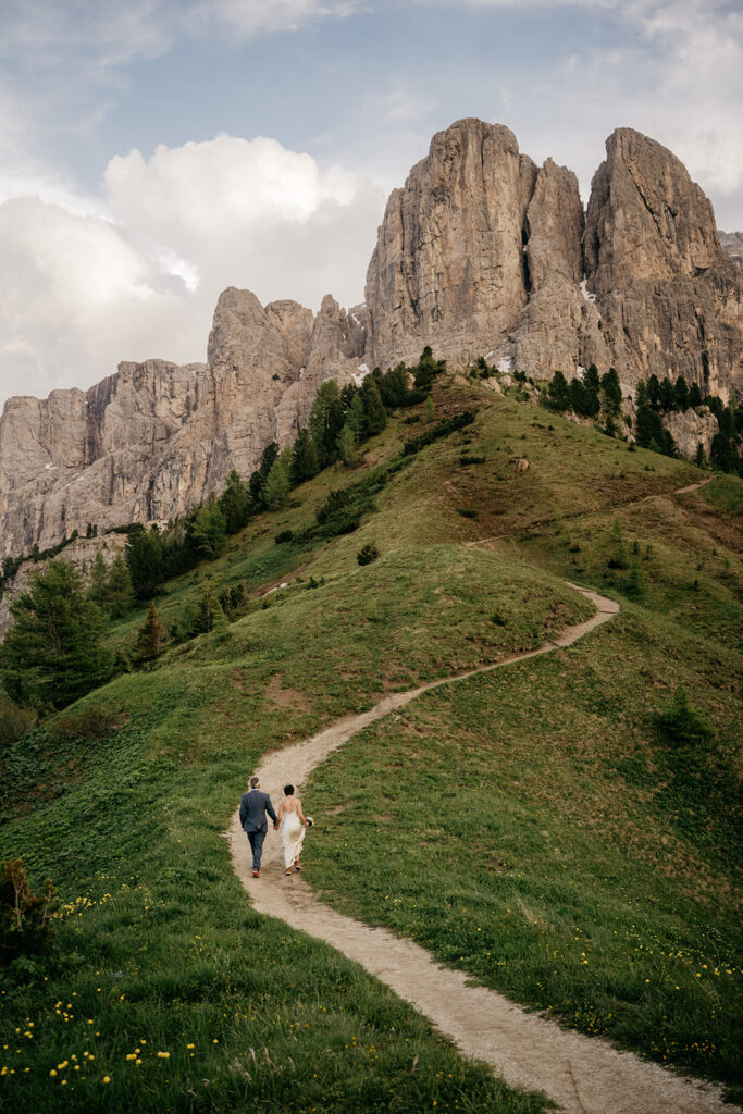 Couple walking on mountain path at majestic sunset