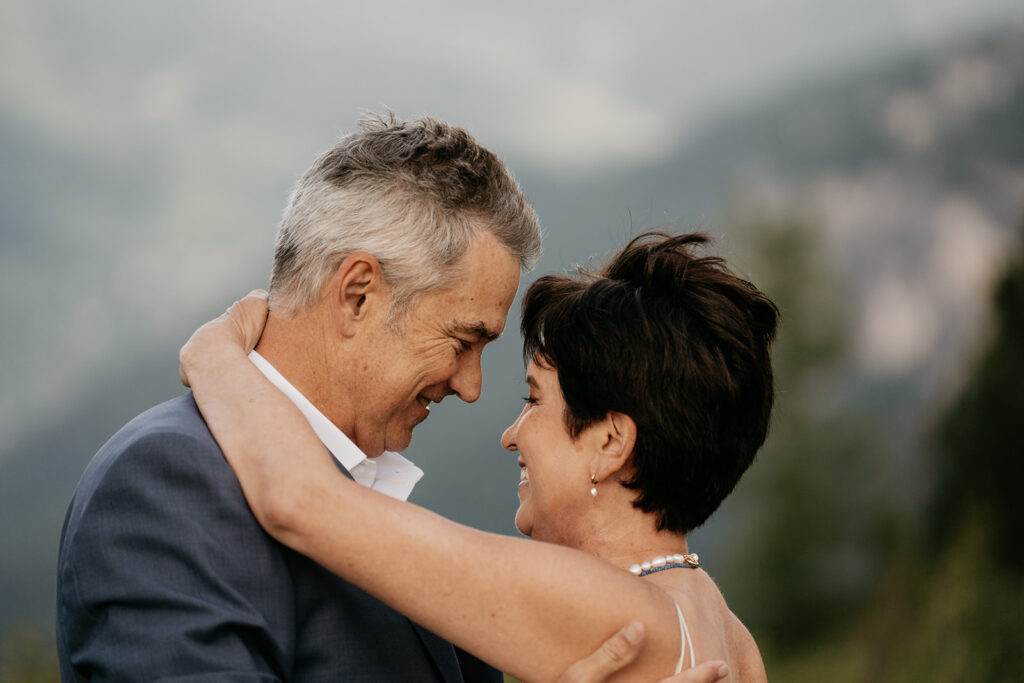 Elderly couple embracing outdoors happily.