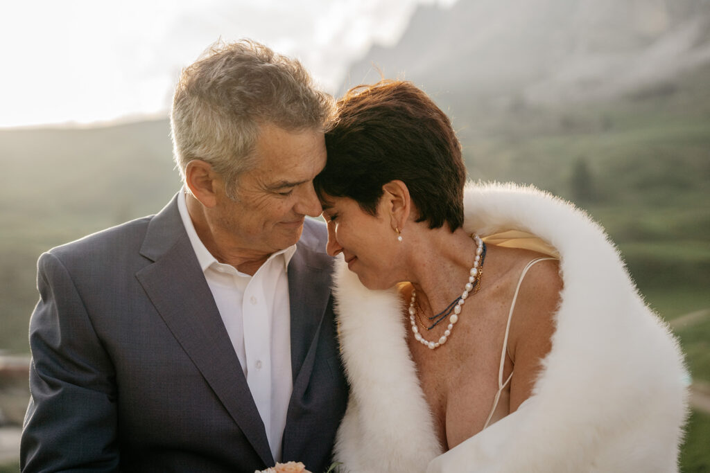 Couple embracing outdoors in elegant attire.