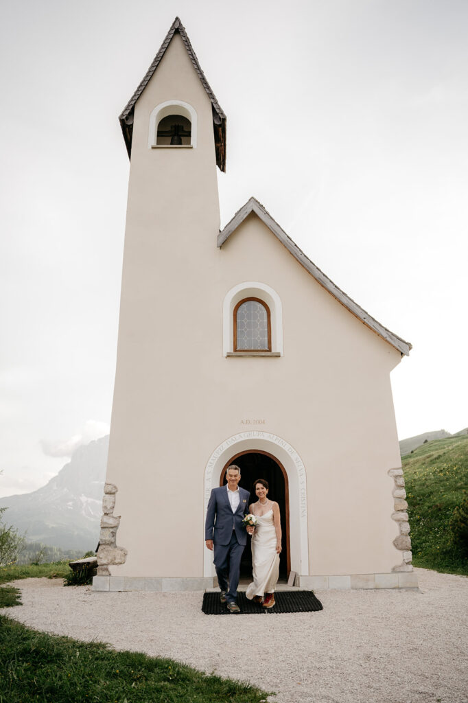 Bride and groom exiting small chapel