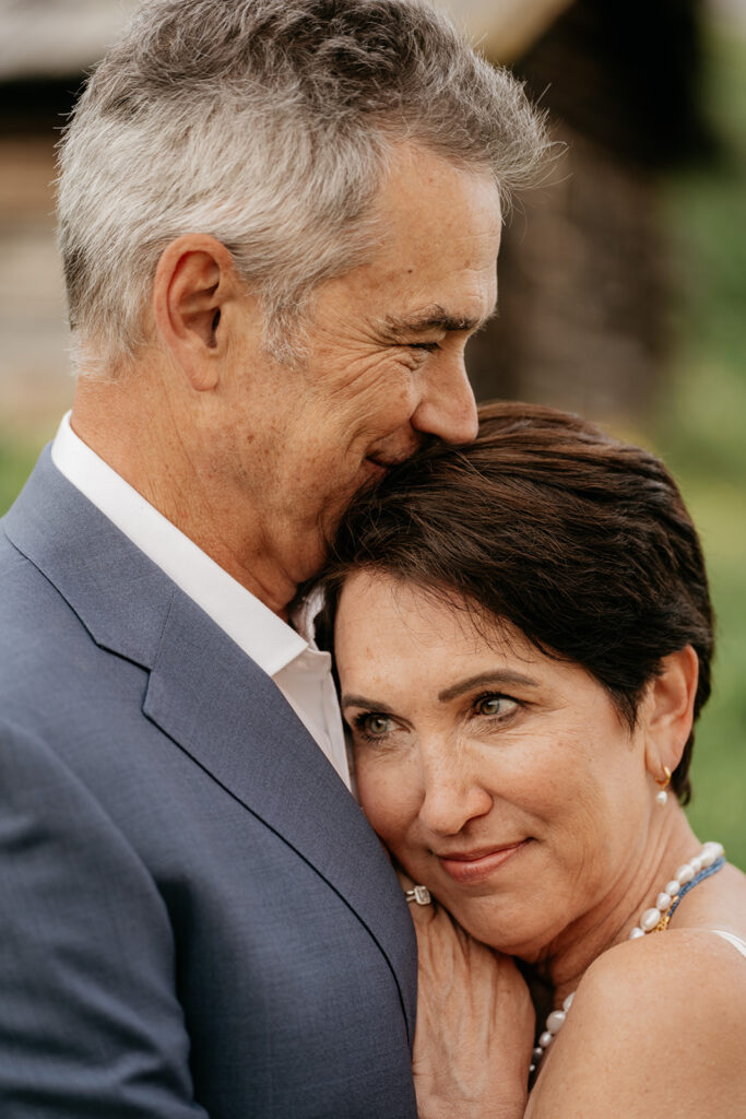 Elderly couple embracing happily outdoors.