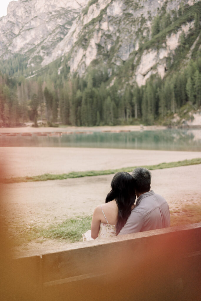 Couple sitting by mountain lake, peaceful view