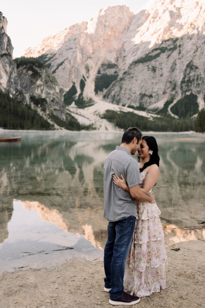 Couple embracing by a serene mountain lake