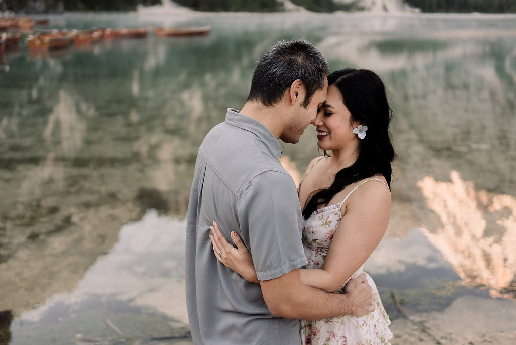 Couple embracing by a serene lake.