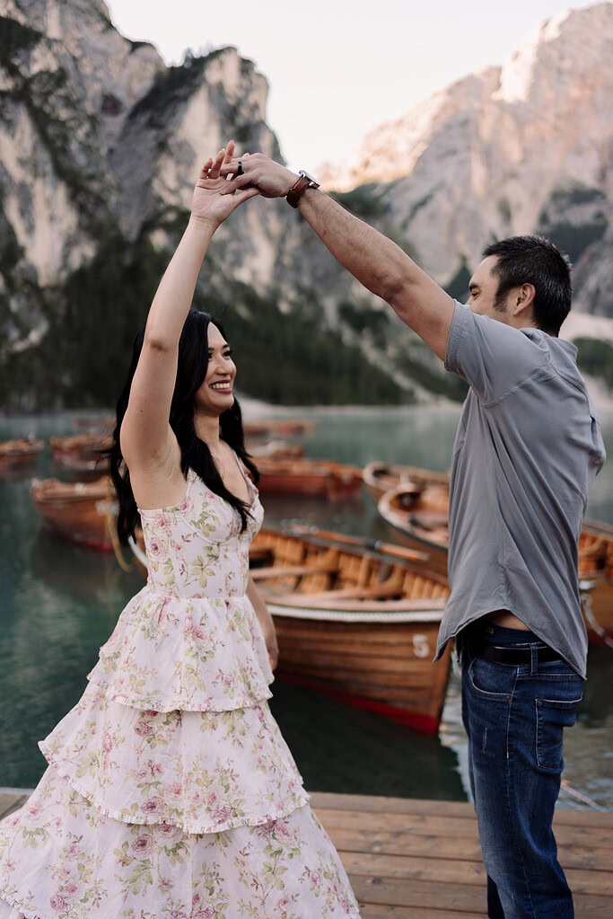 Couple dancing by lake with boats