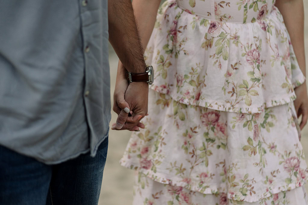 Couple holding hands, floral dress visible