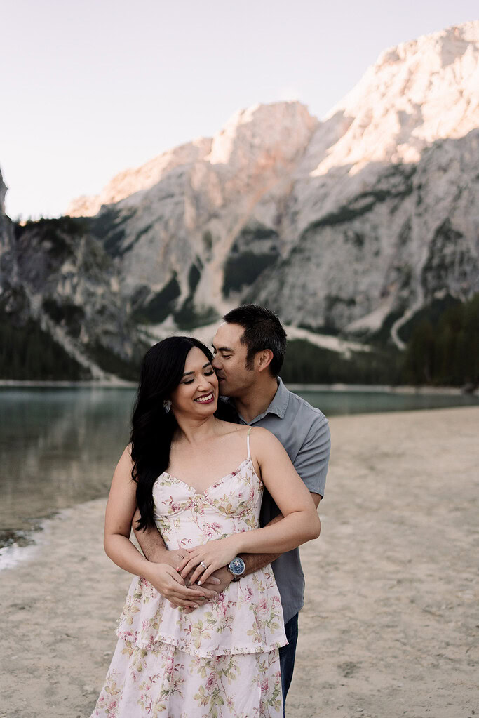 Couple embracing by a mountain lake.