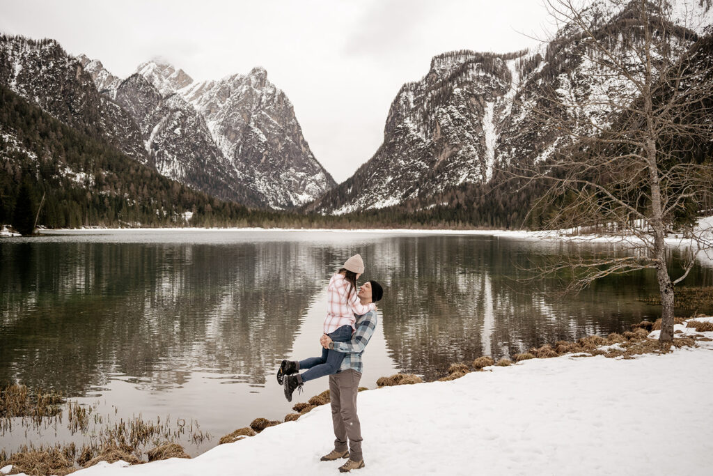 Couple enjoying snowy mountain lake view.