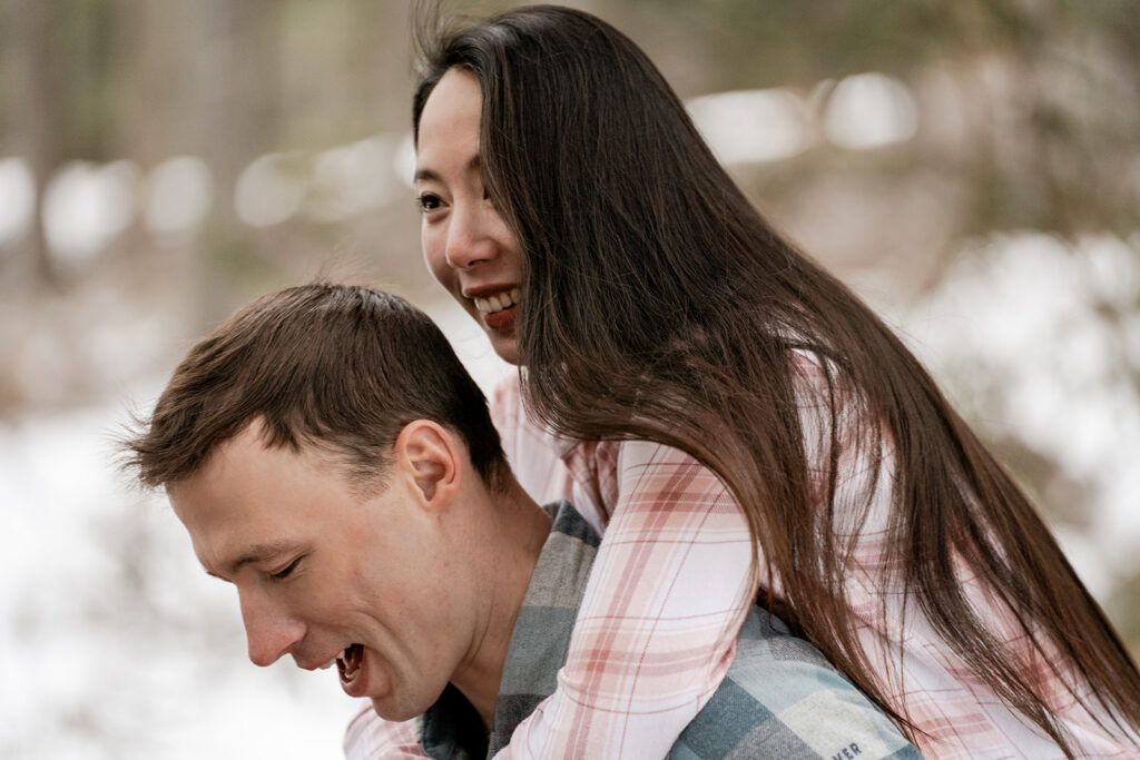 Couple laughing outdoors in winter.