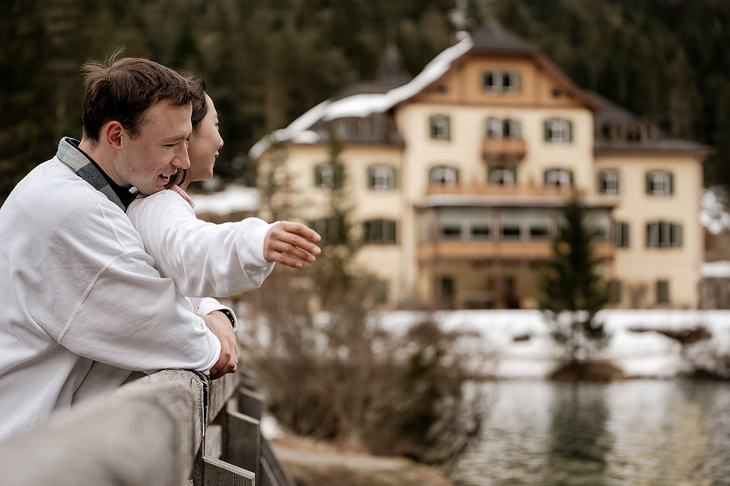 Couple embracing on bridge near scenic lodge