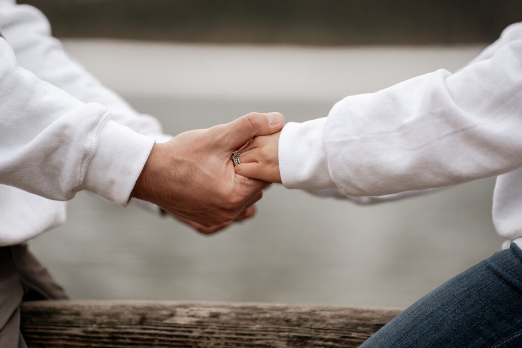 Couple holding hands near water