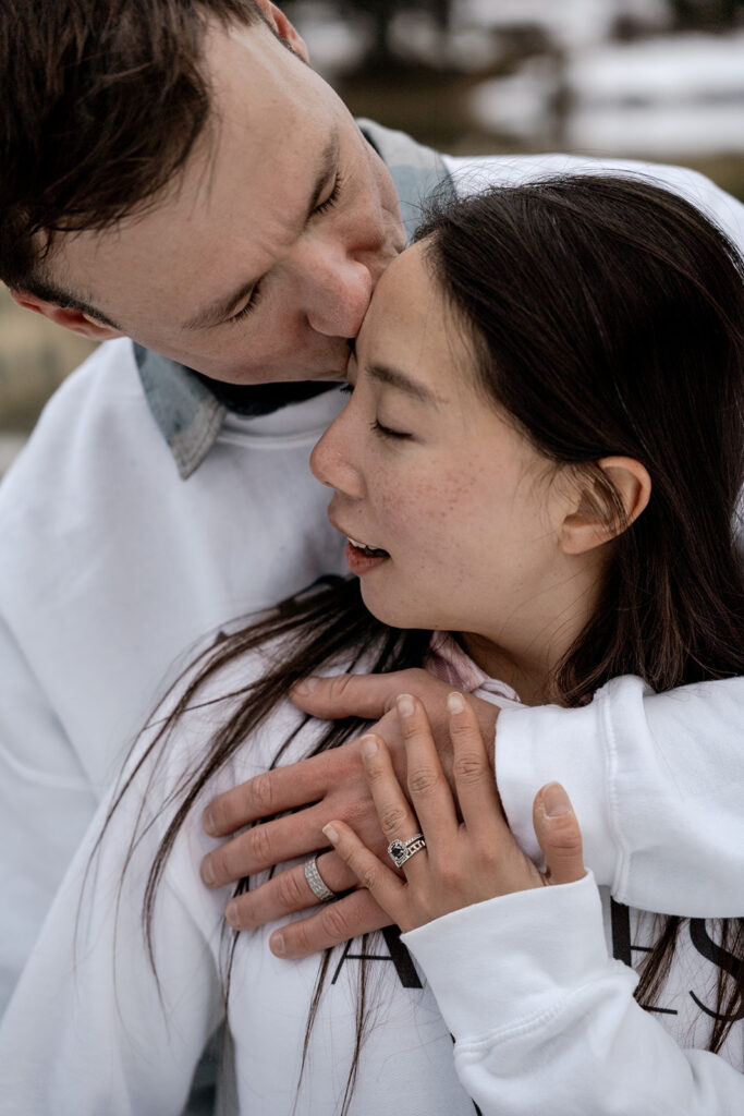 Couple embracing warmly in winter setting.