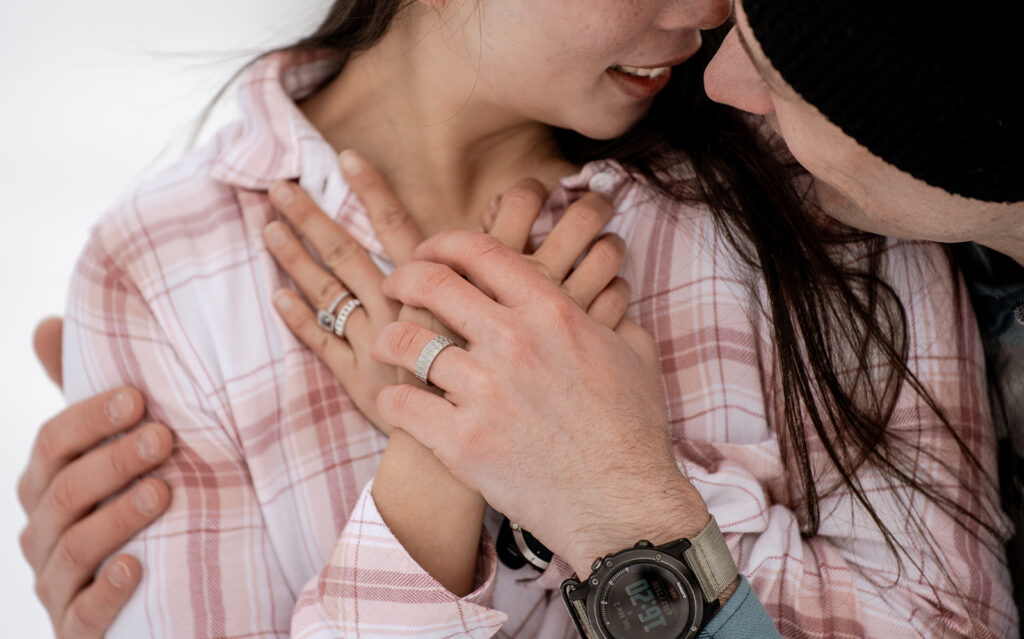 Couple embracing with hands on chest.