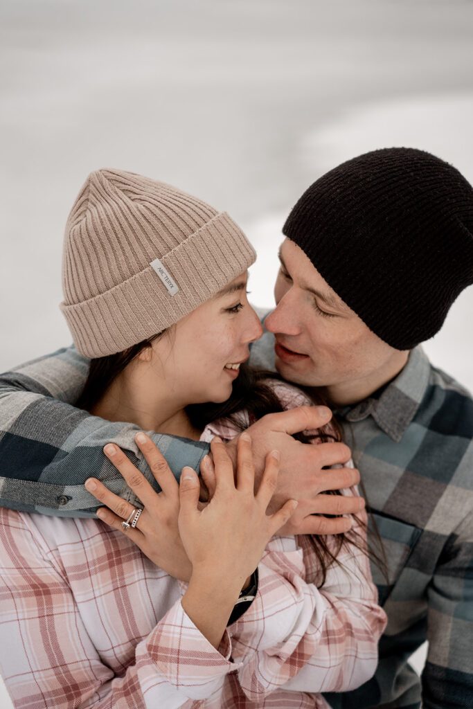 Couple embracing in warm hats and plaid shirts