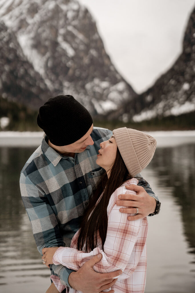 Couple embracing by snowy mountain lake