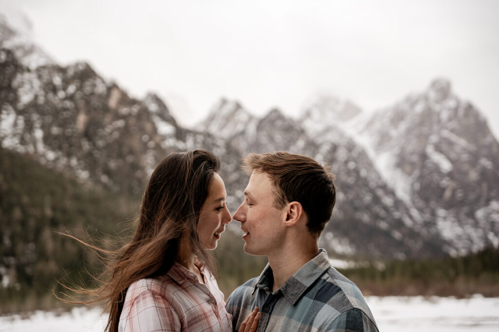 Couple smiling in snowy mountain landscape