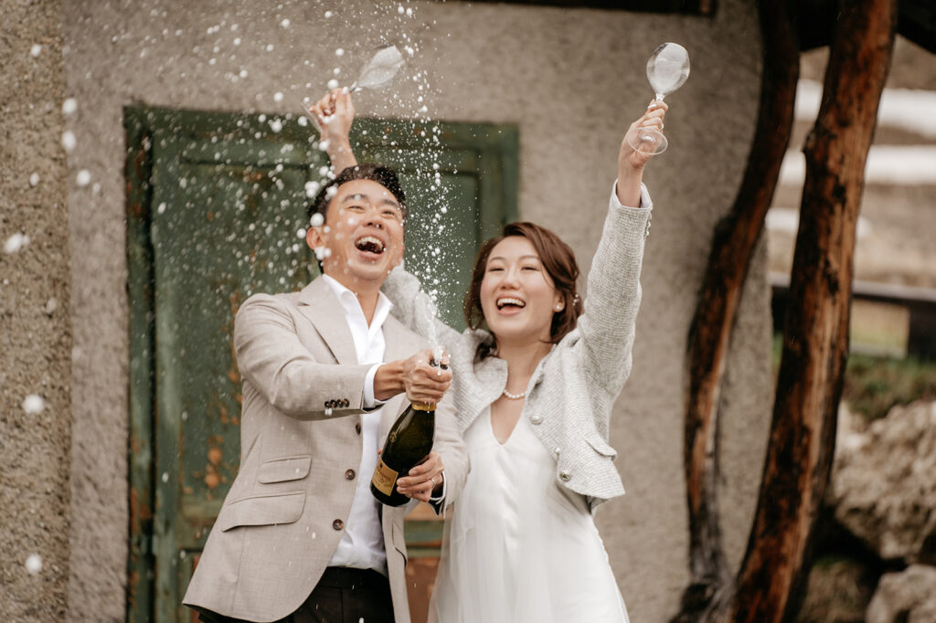 Couple celebrating with champagne outdoors.