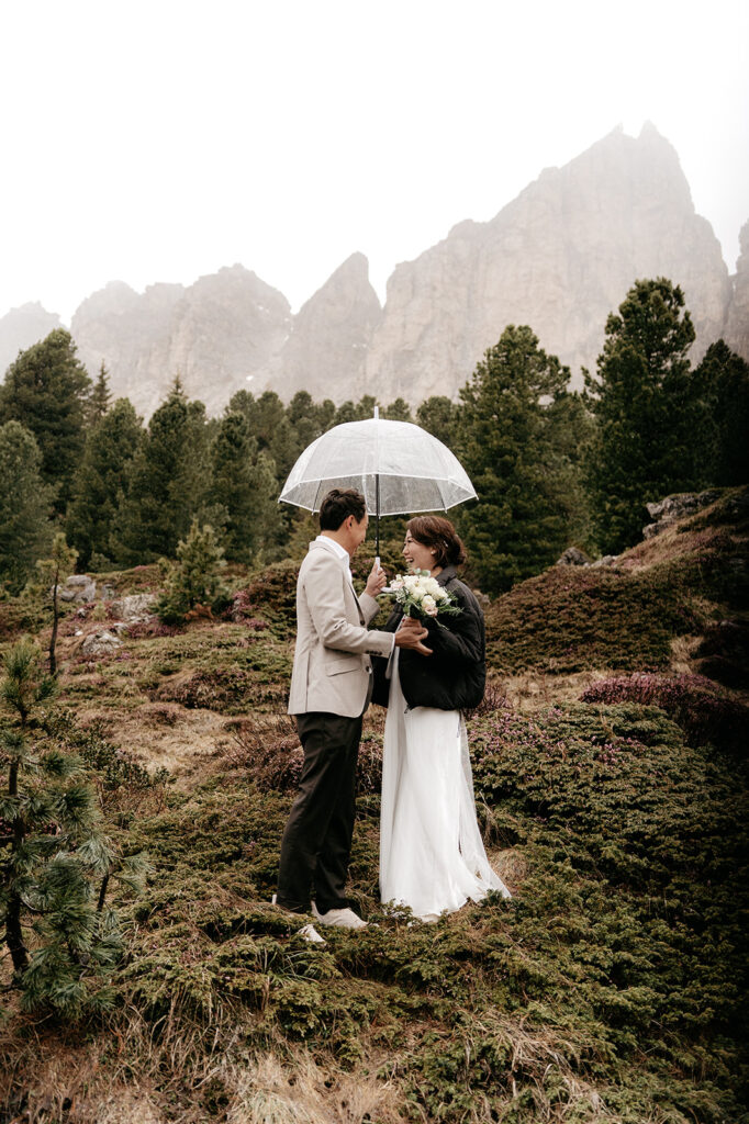 Couple with umbrella in mountain landscape