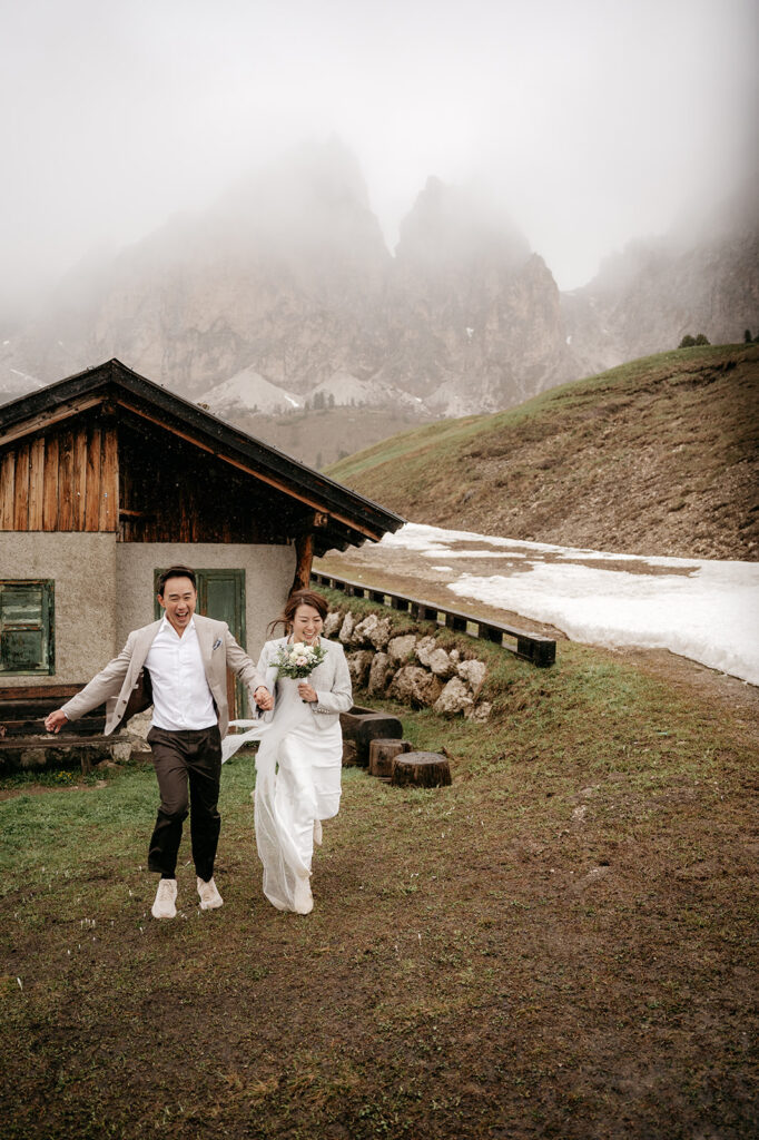 Happy couple running near mountain cabin