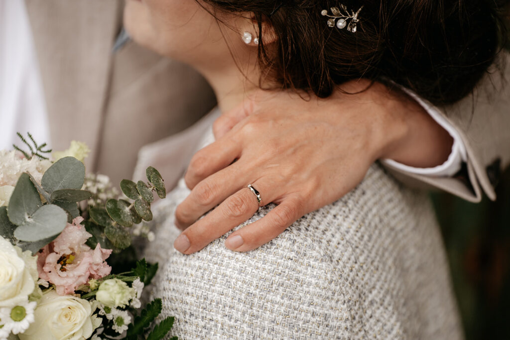 Close-up of couple with bouquet and wedding ring