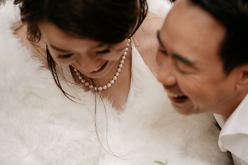 Couple smiling in elegant white attire.