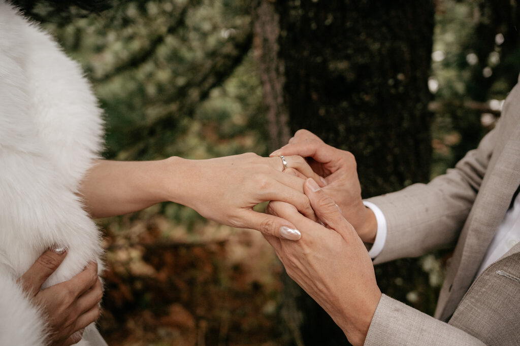 Person placing ring on finger during ceremony