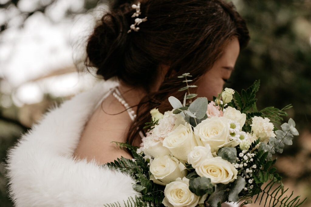 Bride holding bouquet of white roses