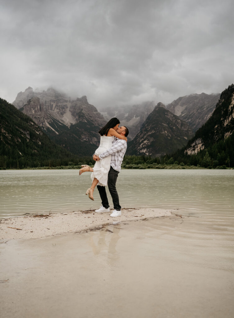 Couple embracing by a mountain lake